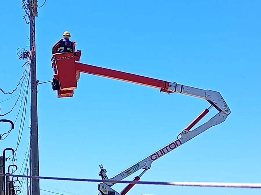 Profissional em cesto aéreo durante inspeção de rede elétrica